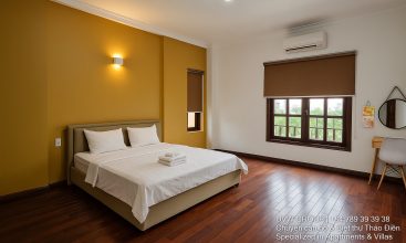 Exterior view of a spacious luxury 7-bedroom villa in Thao Dien, Ho Chi Minh City, featuring a large semi-indoor swimming pool, an elegant living room, a vibrant karaoke lounge with colorful lights, a comfortable king-size bedroom, and modern bathrooms (5 indoor, 3 outdoor).