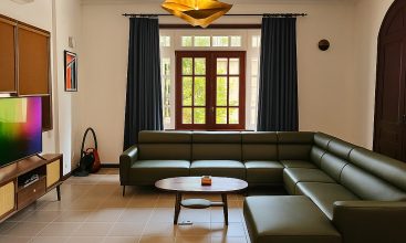 Exterior view of a spacious luxury 7-bedroom villa in Thao Dien, Ho Chi Minh City, featuring a large semi-indoor swimming pool, an elegant living room, a vibrant karaoke lounge with colorful lights, a comfortable king-size bedroom, and modern bathrooms (5 indoor, 3 outdoor).