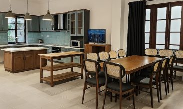 Exterior view of a spacious luxury 7-bedroom villa in Thao Dien, Ho Chi Minh City, featuring a large semi-indoor swimming pool, an elegant living room, a vibrant karaoke lounge with colorful lights, a comfortable king-size bedroom, and modern bathrooms (5 indoor, 3 outdoor).