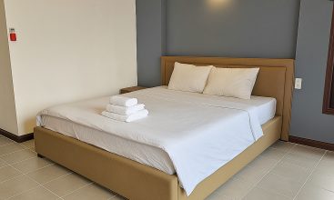 Exterior view of a spacious luxury 7-bedroom villa in Thao Dien, Ho Chi Minh City, featuring a large semi-indoor swimming pool, an elegant living room, a vibrant karaoke lounge with colorful lights, a comfortable king-size bedroom, and modern bathrooms (5 indoor, 3 outdoor).