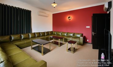 Exterior view of a spacious luxury 7-bedroom villa in Thao Dien, Ho Chi Minh City, featuring a large semi-indoor swimming pool, an elegant living room, a vibrant karaoke lounge with colorful lights, a comfortable king-size bedroom, and modern bathrooms (5 indoor, 3 outdoor).