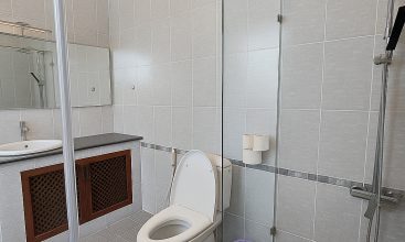 Exterior view of a spacious luxury 7-bedroom villa in Thao Dien, Ho Chi Minh City, featuring a large semi-indoor swimming pool, an elegant living room, a vibrant karaoke lounge with colorful lights, a comfortable king-size bedroom, and modern bathrooms (5 indoor, 3 outdoor).
