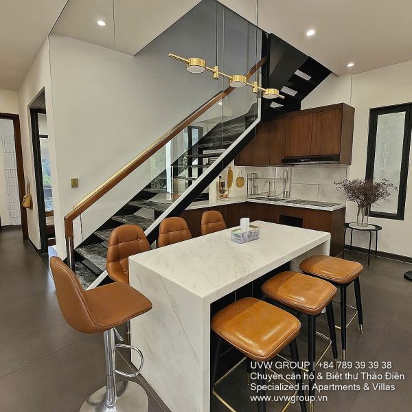 Exterior and interior views of a modern luxury 5-bedroom villa for rent in Thao Dien, Ho Chi Minh City, featuring a unique indoor swimming pool with wooden deck, a stylish living room, a dedicated karaoke room, a king-size bedroom, and 6 contemporary bathrooms (4 indoor, 2 outdoor).